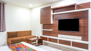 Una sala de estar moderna con sofá, televisor y mueble de entretenimiento.