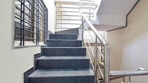 Una escalera con barandales de metal y pasamanos, que conduce a un piso superior.