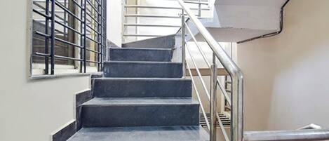 A staircase with metal railings and a handrail, leading to an upper floor.