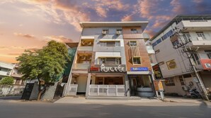 Un hotel de varios pisos con una fachada moderna, un restaurante visible y el letrero del hotel a la vista.