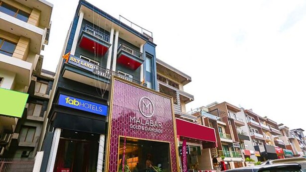 A hotel with a prominent sign for 'Malabar Gold & Diamonds'. - Fabhotel Sky Land (New Delhi)