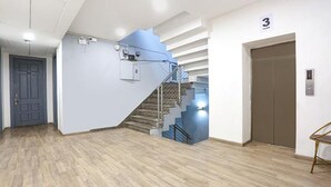 A modern interior with a wooden floor, a staircase, and a door marked with the number 3. - Fabhotel Sky Land (New Delhi)