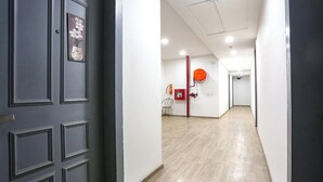 A hallway with a dark door, a framed picture, and a red object on the wall. - Fabhotel Sky Land (New Delhi)