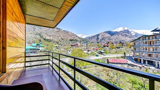 A balcony with a view of a mountainous landscape and buildings.