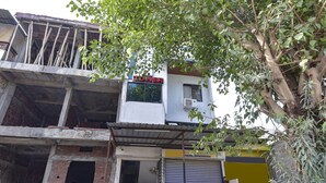 A building with a sign reading "TOWER" and a closed shutter door. - Fabexpress Nishesh Tower (Ujjain)