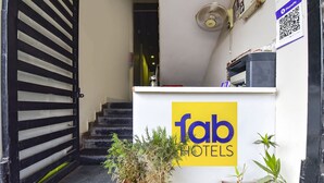 A hotel entrance with a sign reading "fab hotels," a potted plant, and a staircase leading inside. - Fabexpress Nishesh Tower (Ujjain)