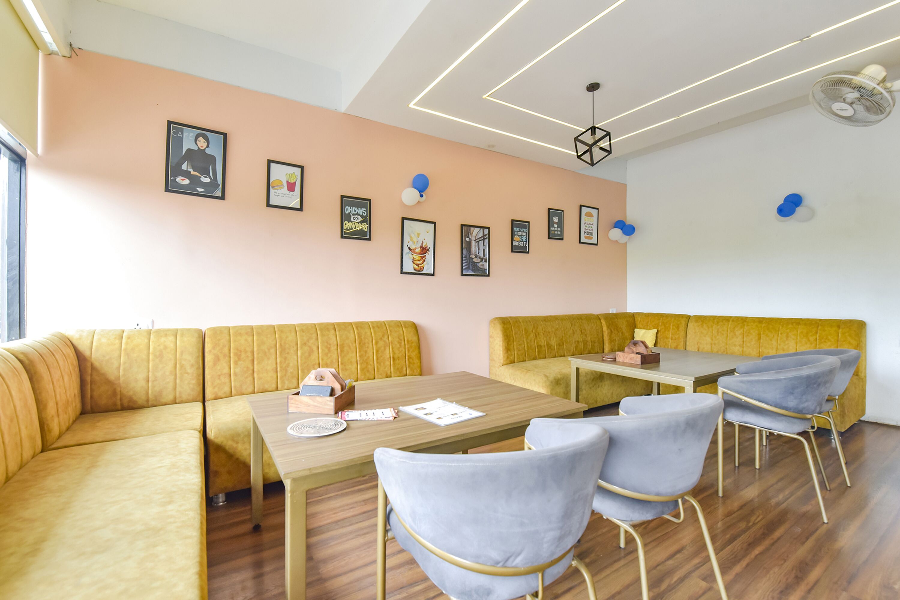 Eine moderne Lounge mit einem gelben Sofa, einem Holztisch und grauen Stühlen.