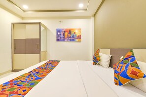 A hotel room with a bed, a colorful runner, a cityscape painting, and a wardrobe. - Fabhotel Urban Elite (Indore)