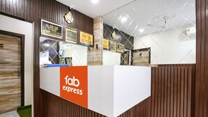 Un comptoir d’accueil avec une enseigne indiquant « service rapide », un lambris en bois et un miroir qui reflète l’intérieur.