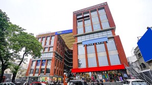 Un immeuble à plusieurs étages doté d’une façade rouge et bleue bien visible, sur laquelle on peut lire une enseigne indiquant « Sahal Icon Hotel ».