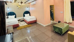 A modern bedroom with a ceiling fan, a chandelier, and a bed with a headboard. - Hotel Prince Nayagarh (Nayagarh)