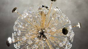 A chandelier with multiple crystal elements and gold accents. - Hotel Prince Nayagarh (Nayagarh)