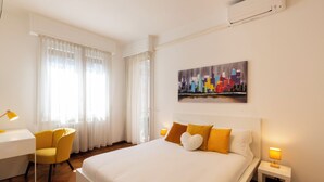 Une chambre d’hôtel avec un grand lit, un bureau avec une chaise, une table de chevet avec une lampe et un tableau au mur.