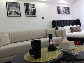 Studiosuite – deluxe, byutsikt | Oppholdsområde | En 24-tommers smart-TV med digitale kanaler