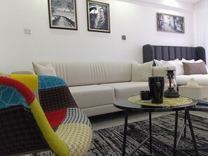 Studiosuite – deluxe, byutsikt | Oppholdsområde | En 24-tommers smart-TV med digitale kanaler