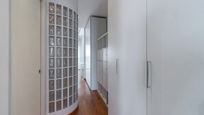 A hallway with a glass partition, white walls, and wooden flooring. - Italianway Comfort - Savona 123 (Milan)