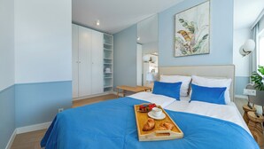 Una camera da letto con un letto, un vassoio per la colazione e un quadro appeso al muro.