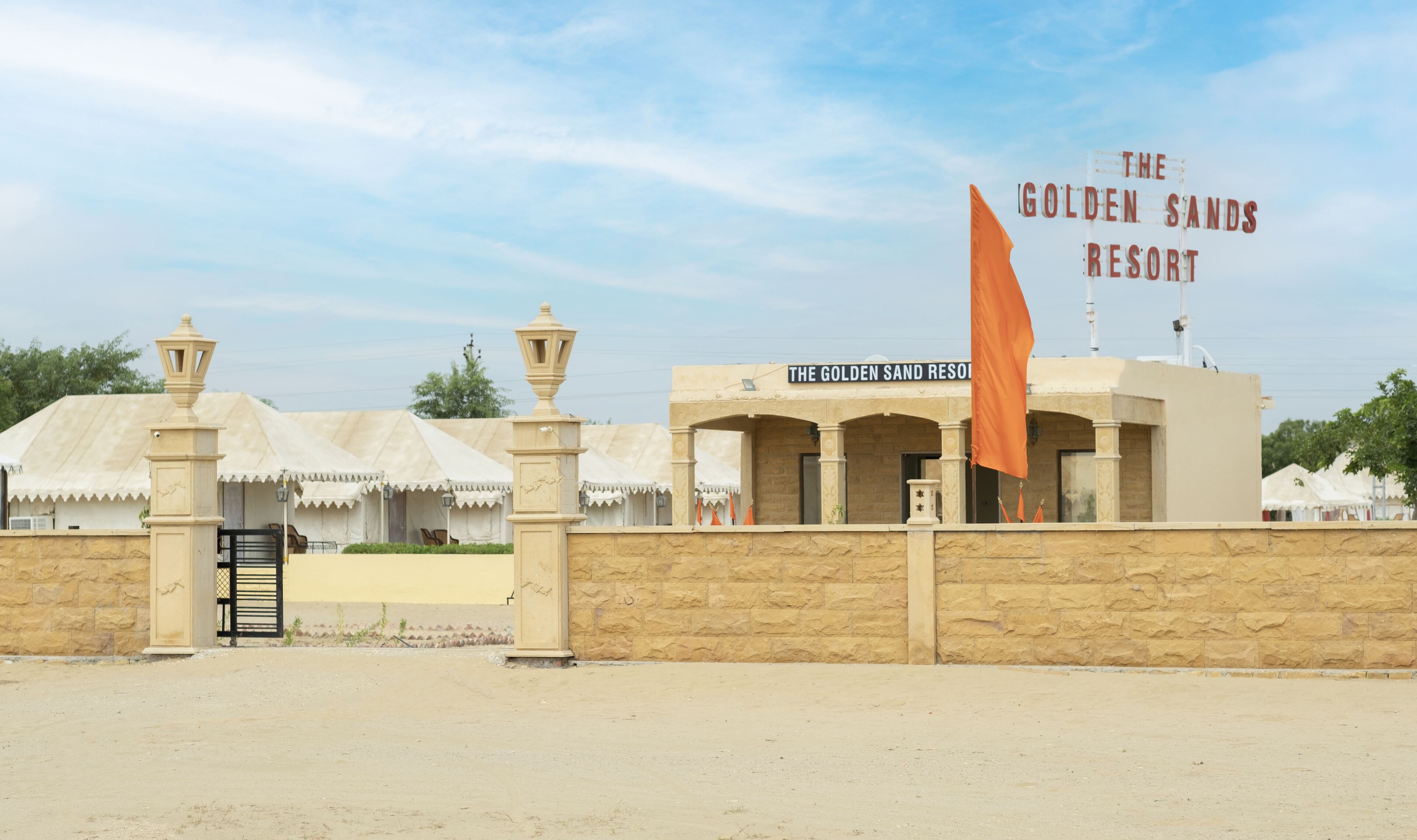 Il Golden Sands Resort, con una targa, un muro in pietra e una bandiera.