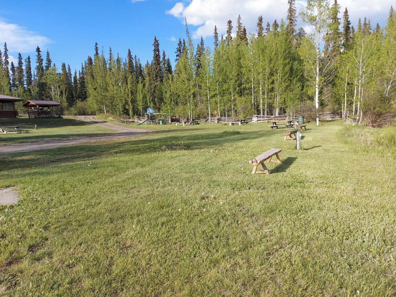 A campground with picnic tables and cabins.