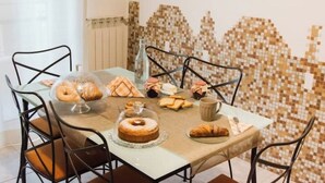 A dining table with various pastries and a cake, surrounded by chairs.