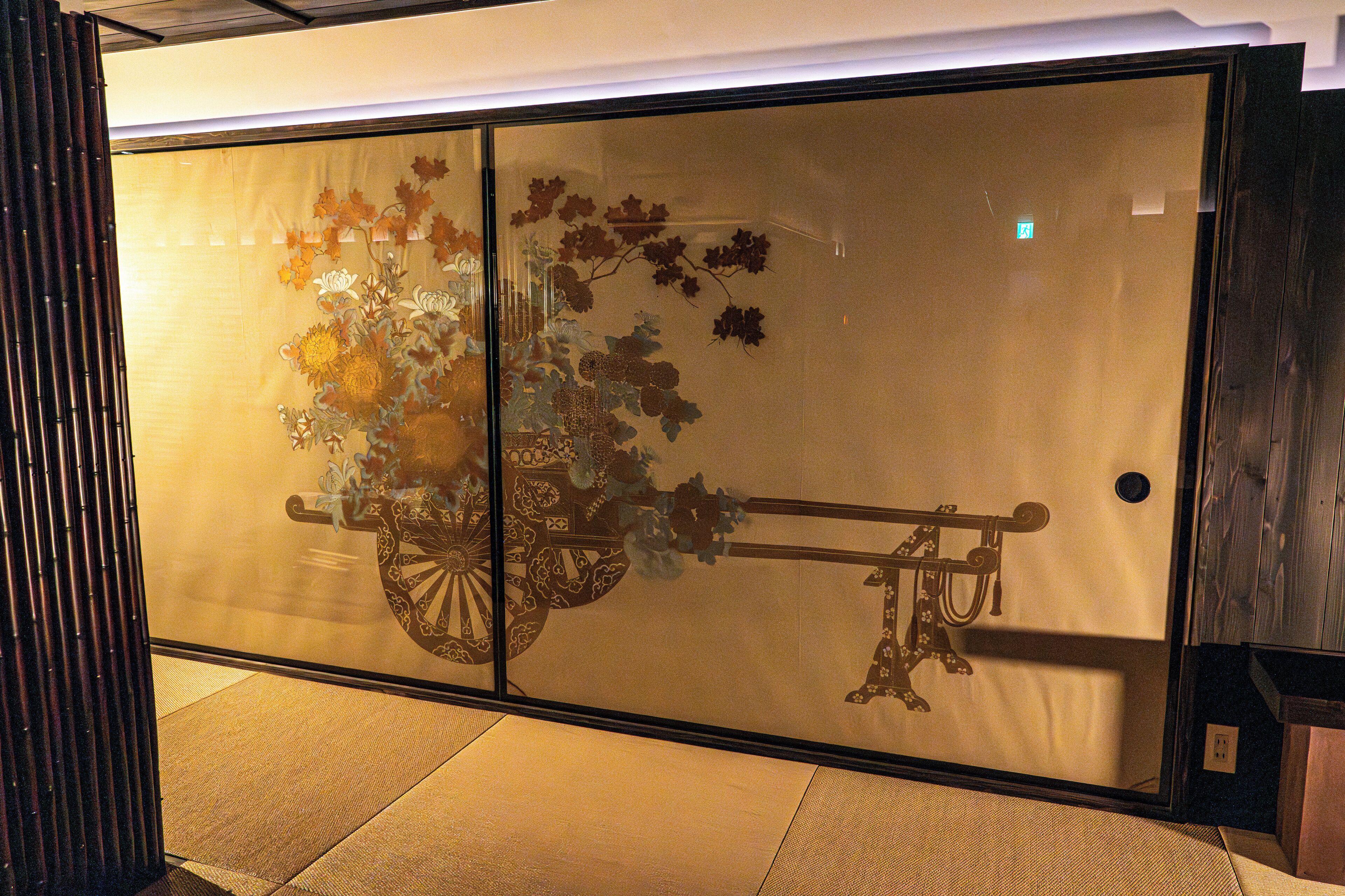 A traditional sliding door with a floral design and a decorative cart.