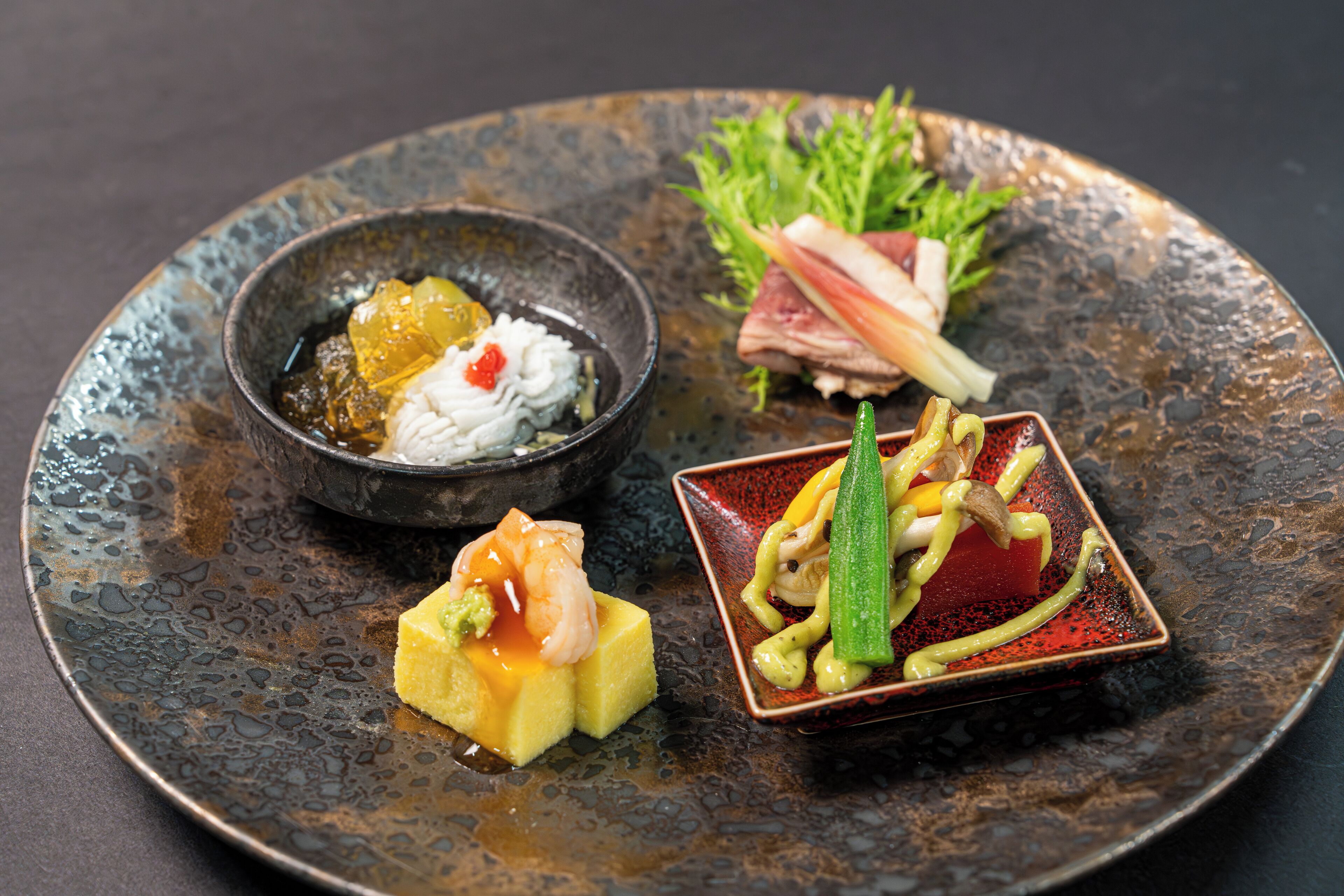 A plate with various dishes including sushi, sashimi, and a bowl of soup.