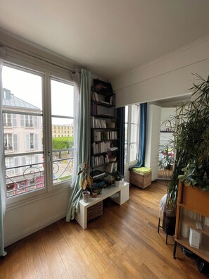 Enjoy the city view from the comfort of this stylish living room, featuring a large window, console table, and bookshelf.