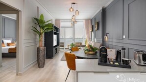 Een moderne hotelkamer met een groot bed, een zithoek met koffie faciliteiten en uitzicht op de stad.