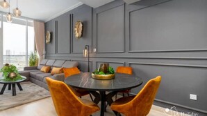 Een moderne eetruimte met een ronde tafel, twee stoelen en een bank.