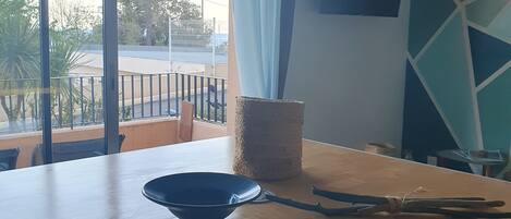 Un comedor con una mesa de madera, un tazón azul y un par de pinzas.