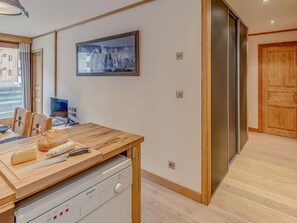 Una cocina moderna con encimera de madera, horno empotrado y un amplio ventanal.