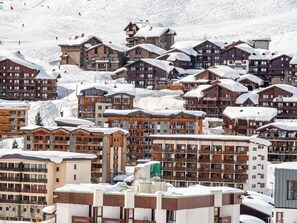 A snow-covered mountain resort with multiple wooden buildings, including a hotel named 'Village Montana.' - Tignes - 3-room apartment, 6 pers, hotel services (Tignes)