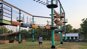 Ein Spielplatz im Freien mit verschiedenen Klettergerüsten und einer überdachten Sitzgelegenheit.