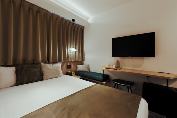 A hotel room with a large bed, a desk, a chair, a flat-screen TV, and a window with curtains. - R Hotel Namba Daikokucho (Osaka)