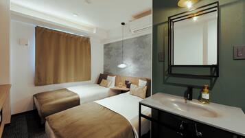 A hotel room with two beds, a bathroom with a mirror, and a bedside table.