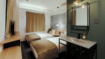 Habitación de hotel con dos camas, un escritorio, un espejo y un baño con lavamanos y espejo.