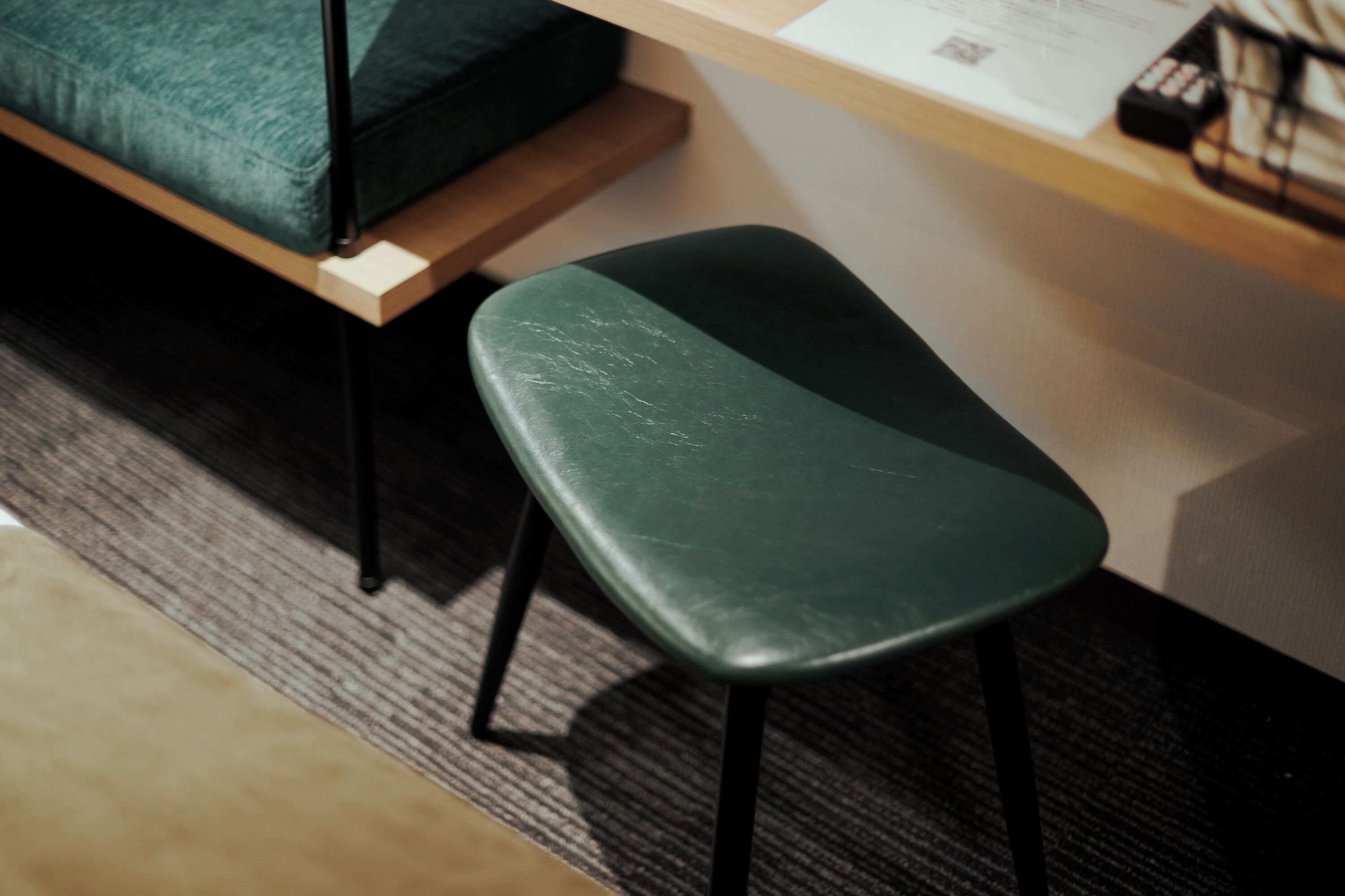 A green stool with a wooden table beside it.