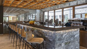 A modern bar area with a stone countertop, bar stools, and a wooden ceiling. - Premium apartment with 2 bedrooms (Ehrwald)