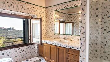 Un baño con un ventanal grande, un lavabo y un espejo.