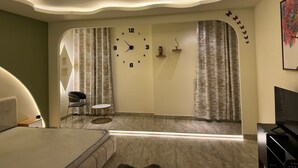 A modern bedroom with a curved ceiling, a large bed, a desk, and a chair.