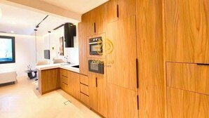 A modern kitchen with wooden cabinets, a built-in oven, and a sink.