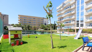 A courtyard with a small play area, a slide, and a pool. - S333-190 LARIMAR SUPERIOR FAMILY COMPLEX (Salou)