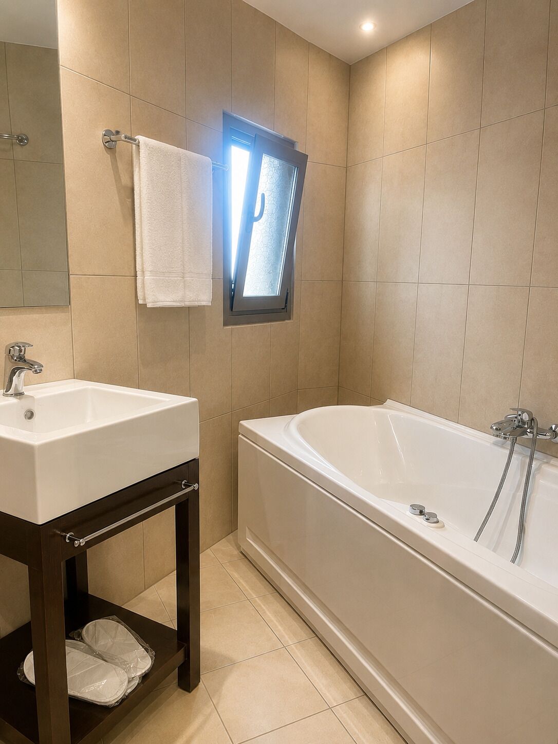A bathroom with a sink, mirror, towel rack, and a bathtub.