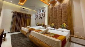 A hotel room with two beds, a ceiling fan, and a wooden headboard. - Hotel Bhagya Laxmi (Abu Road)