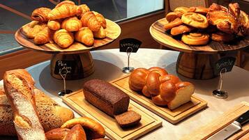 Een bakkerijdisplay met verschillende broden en gebak.