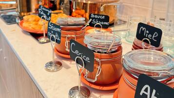 Un mostrador de buffet con recipientes etiquetados de salsas y condimentos.