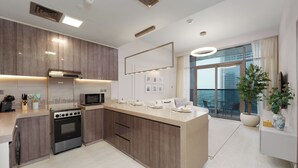 Een moderne keuken met een inbouwoven, magnetron en een groot kookeiland met eettafel.