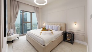 Een moderne slaapkamer met een groot bed, een nachtkastje, een stoel en uitzicht op een stadsgezicht door een groot raam.