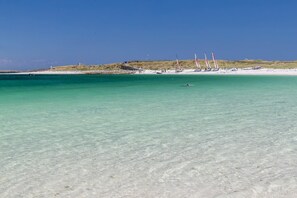 A beach with clear turquoise water, a sandy shore, and a few sailboats in the distance. - New house 400 m from Lodonnec Beach... LOCTUDY (Loctudy)