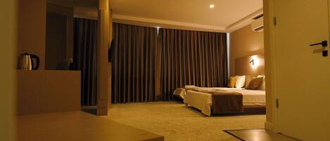 A hotel room with a bed, bedside table, and a large mirror.